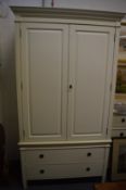 A good cream painted wardrobe, the upper section with a pair of panelled doors above a base with two