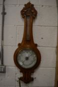 Carved oak cased barometer and thermometer.