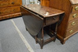 A 19th century oak drop-leaf gateleg dining table with a drawer to one end.