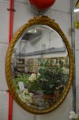 A small oval gilt framed mirror.
