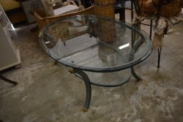 A stylish wrought iron and glass oval two-tier coffee table.