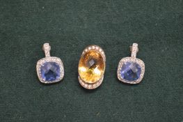 A pair of decorative silver earrings and a pendant.