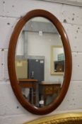 A mahogany framed oval mirror.