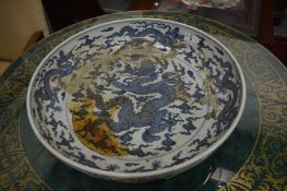 A large Chinese blue and white circular dish decorated with dragons.