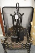 A cast iron fire grate, wrought iron companion set and a spark guard.
