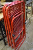 A set of four Italian red painted metal folding chairs.