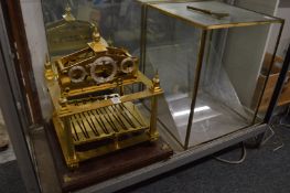A Congreve rolling ball clock with glass case (glass damaged).