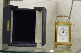 A small brass carriage clock with travelling case.