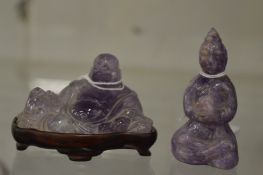 Two Chinese amethyst jadeite Buddha's, one seated on a hardwood base.