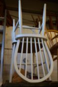 A pair of white painted stick back chairs.