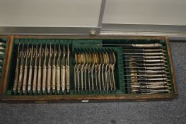 Comprehensive plated canteen of cutlery contained in three oak drawers.