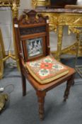 A pair of Victorian walnut hall chairs, the carved panelled backs inset with allegorical porcelain