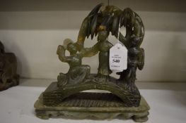 A Chinese carved soap stone group of three figures on a bridge.
