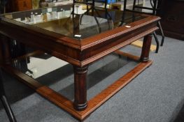 A large glass and mahogany framed two-tier coffee table.