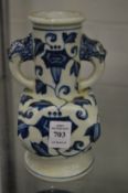 A Chinese blue and white vase with mask handles.