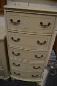A cream painted narrow chest of drawers.