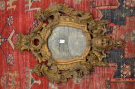 A good early carved wood shield shaped mirror.