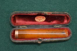 A gold mounted amber cigarette holder, cased.