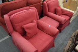 A pair of red upholstered armchairs and matching footstool.