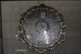 A good early Victorian salver with engraved decoration, cast shell border and scroll feet.