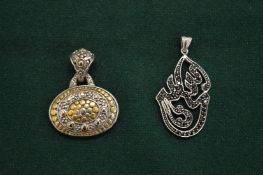 Two decorative silver pendants.