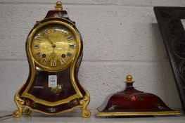 A decorative French style mantel clock with clock bracket.