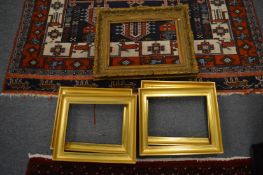 A set of four small gilt frames together with a larger gilt frame.