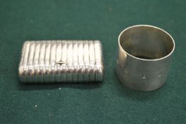 A silver snuff box of ribbed design and a plain silver napkin ring.
