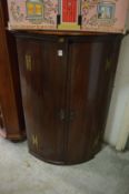 A mahogany corner cupboard.