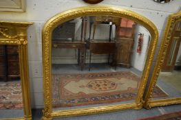 A large Victorian style gilt framed over mantel mirror with arched top.