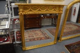 A gilt framed over mantel mirror with ribbon and swag decoration.