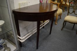 A mahogany demi-lune fold-over card table.