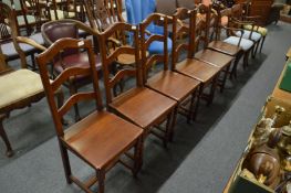 A set of modern oak ladder back solid seat dining chairs.