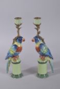 A PAIR OF PORCELAIN PARAKEET CANDLESTICKS on pedestal bases. 12ins high.
