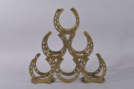 A BRASS HORSESHOE WINE RACK. 16ins high.
