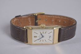 A GOLD OMEGA WRIST WATCH with leather strap in a box.
