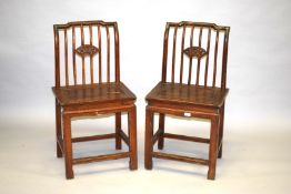 A PAIR OF CHINESE WOODEN CHAIRS with solid seats.