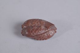A WOODEN NETSUKE carved as four fishes. Signed.