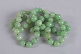 A STRING OF JADE BEADS. 32ins long.