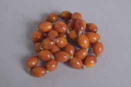 A STRING OF AMBER BEADS. 28ins long.