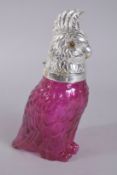 A LARGE SILVER PLATED NOVELTY CRANBERRY COLOURED GLASS PARROT JUG.