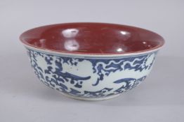 A CHINESE COPPER RED, BLUE AND WHITE PORCELAIN DRAGON BOWL. 26.5cms diameter.