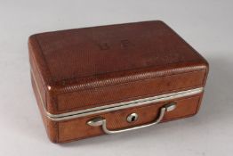 A TRAVELLING LEATHER BOUND VANITY SET with fitments and its key. 7.5ins high.