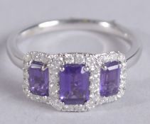 A 9CT WHITE GOLD TRIPLE CLUSTER DRESS RING set with step cut amethysts surrounded by RBC diamonds.