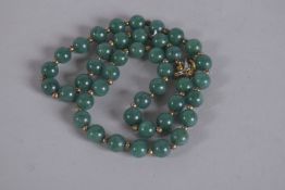A JADEITE BEAD NECKLACE. 17ins long.