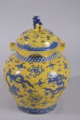 A CHINESE YELLOW GROUND BLUE AND WHITE PORCELAIN DRAGON GINGER JAR AND COVER. 31cms high.