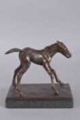 SALLY ARNUP (1930-2015). A PATINATED BRONZE FIGURE OF A YOUNG FOAL, mounted on a polished granite