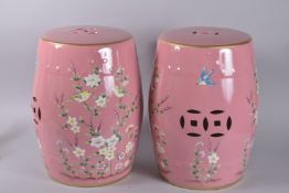 A PAIR OF CHINESE PINK PORCELAIN BARREL SEATS painted with flowers. 17.5ins high.
