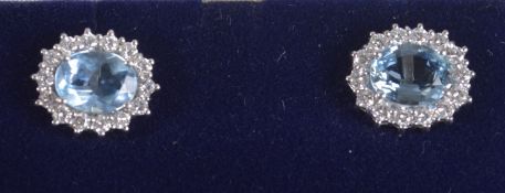 A PAIR OF 18CT GOLD AQUAMARINE AND DIAMOND OVAL CLUSTER EAR STUDS.