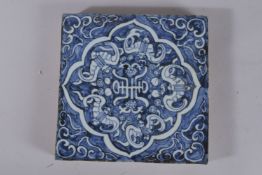 A CHINESE BLUE AND WHITE GLAZED POTTERY TEMPLE TILE. 20cms square.